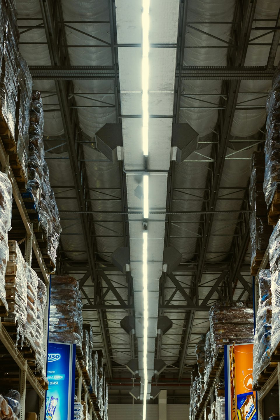 Warehouse aisle with tall shelves full of merchandise.