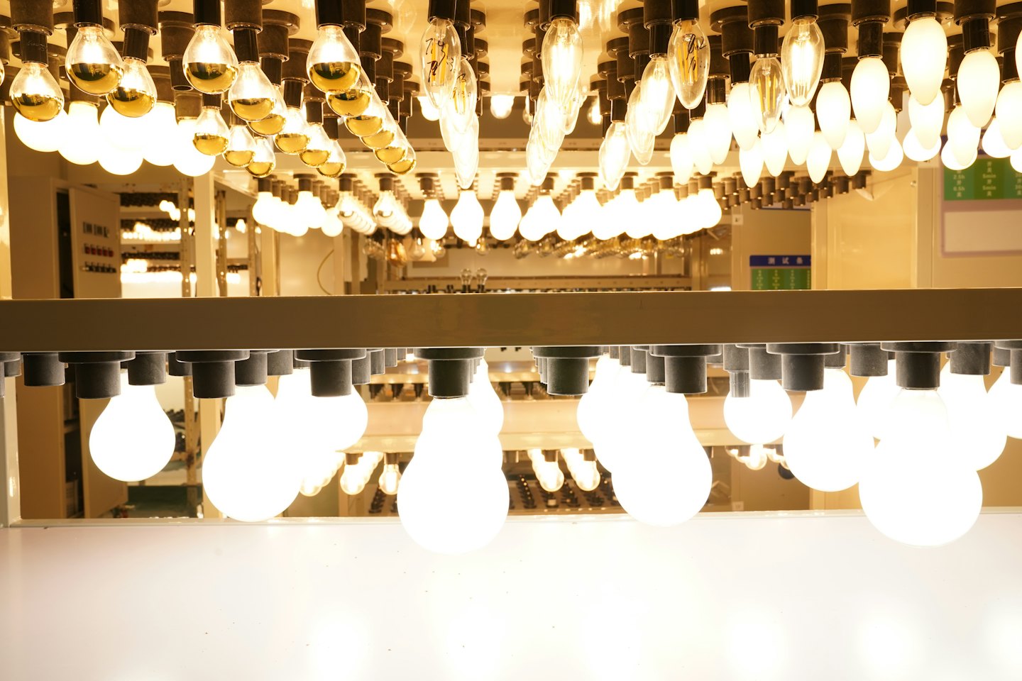Many light bulbs of different types glowing brightly indoors.
