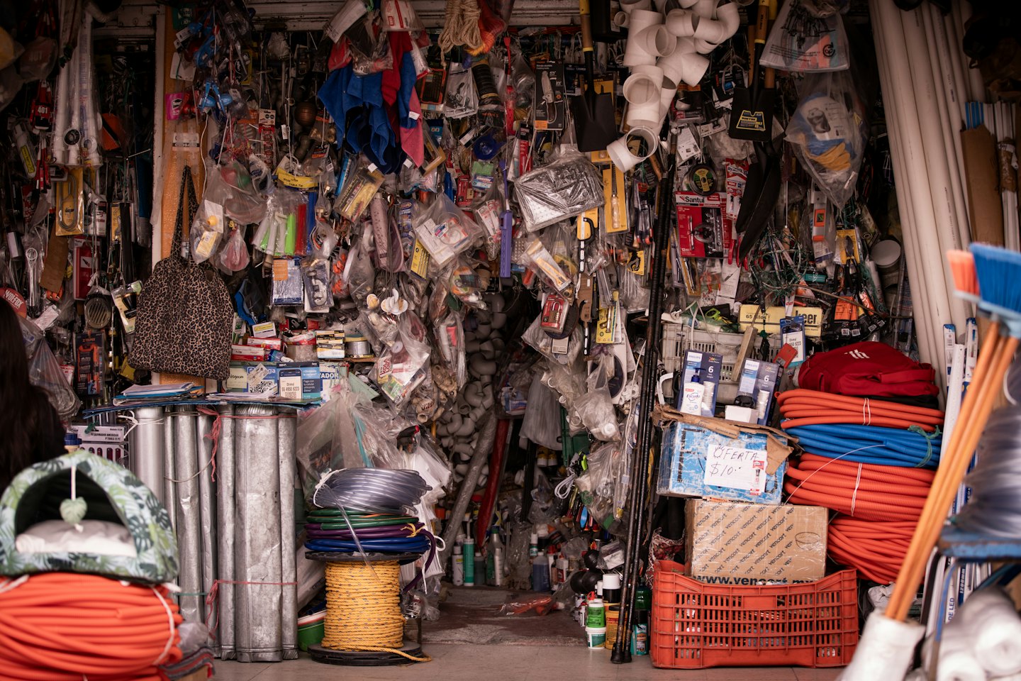 Hardware store shelves packed with tools and colorful coiled ropes.